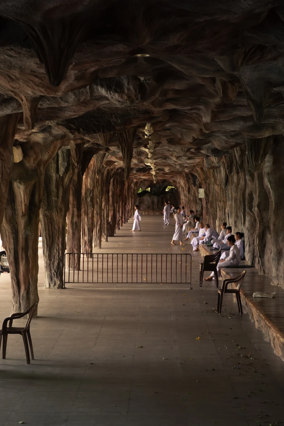 Buddhists meditating within a cave like structure by a water feature in Wat Maheyong, Ayutthaya.