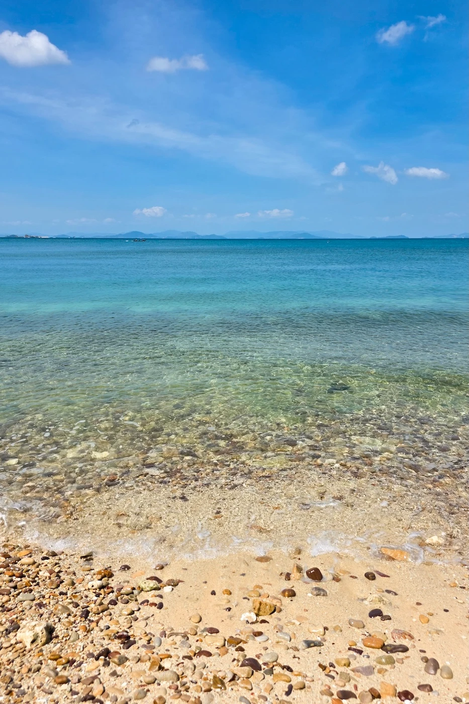 Clear waters by a sand and pebble coastline at Ao Muong Beach.