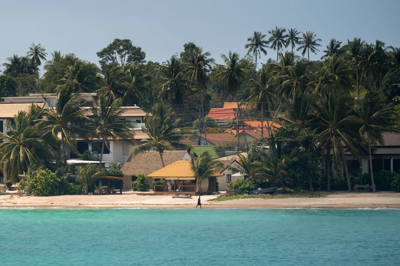 A person walking along the beach front on Koh Samui, Thailand.