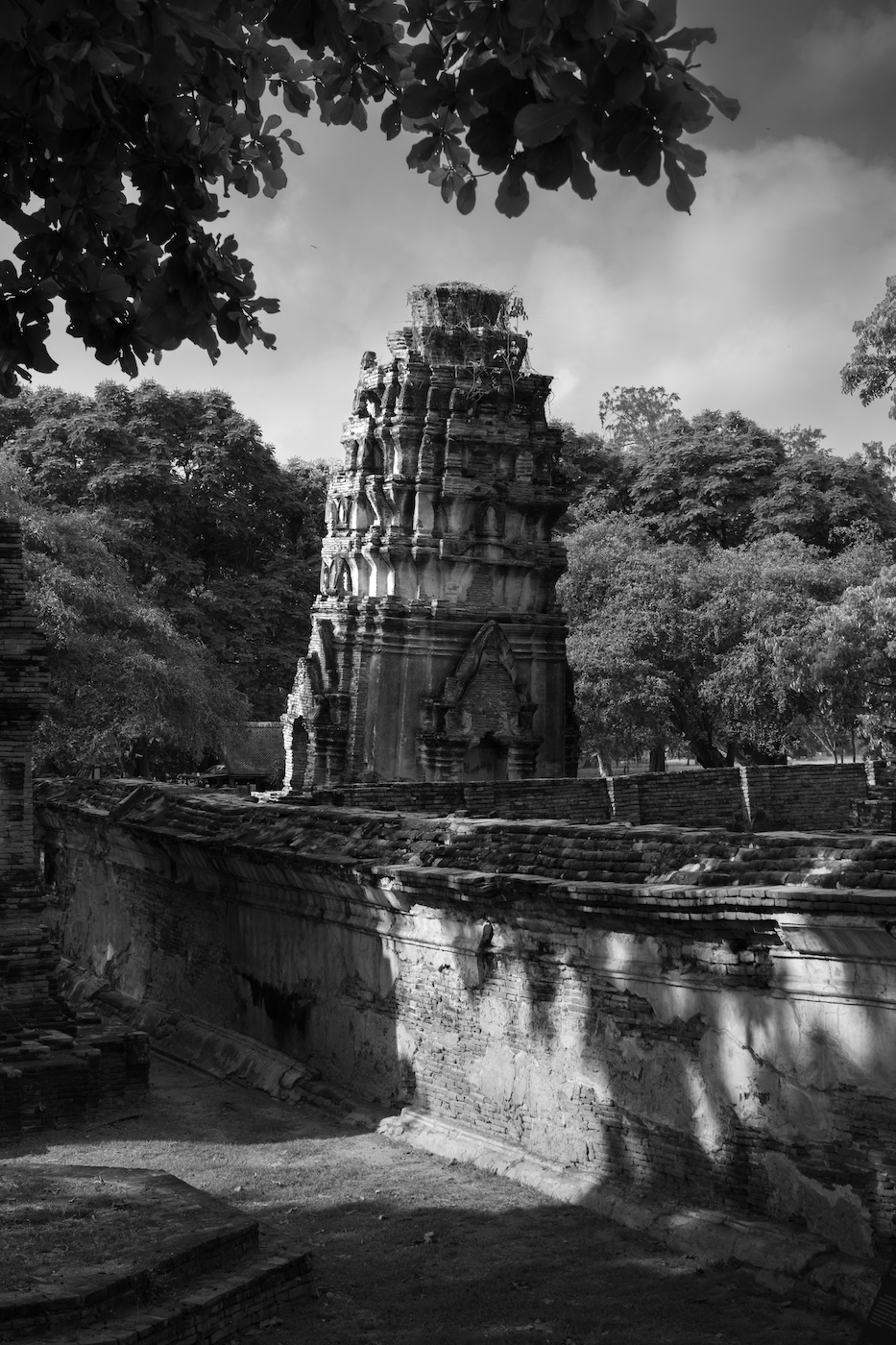 A black and white photo of a leaning prang tower at the ruins of Wat Ratchaburana in Ayutthaya.