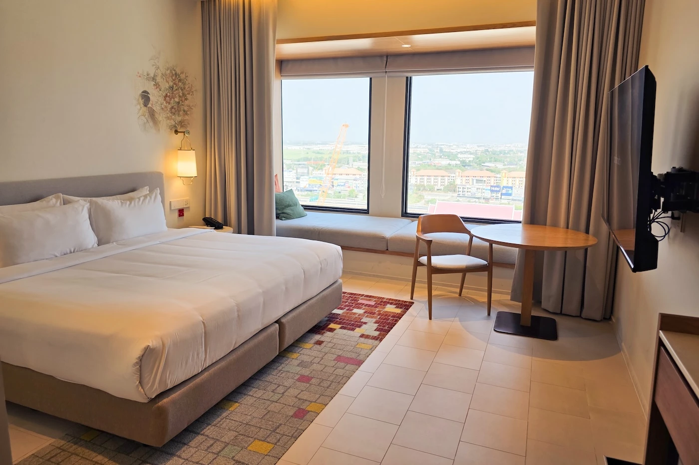 Large, well lit bedroom with a window seating area at the Centara Ayutthaya Hotel.