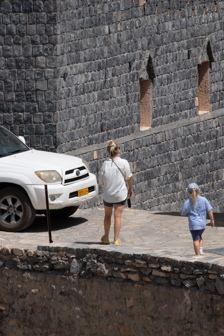 A person wearing inappropriate short clothing in an Omani village.