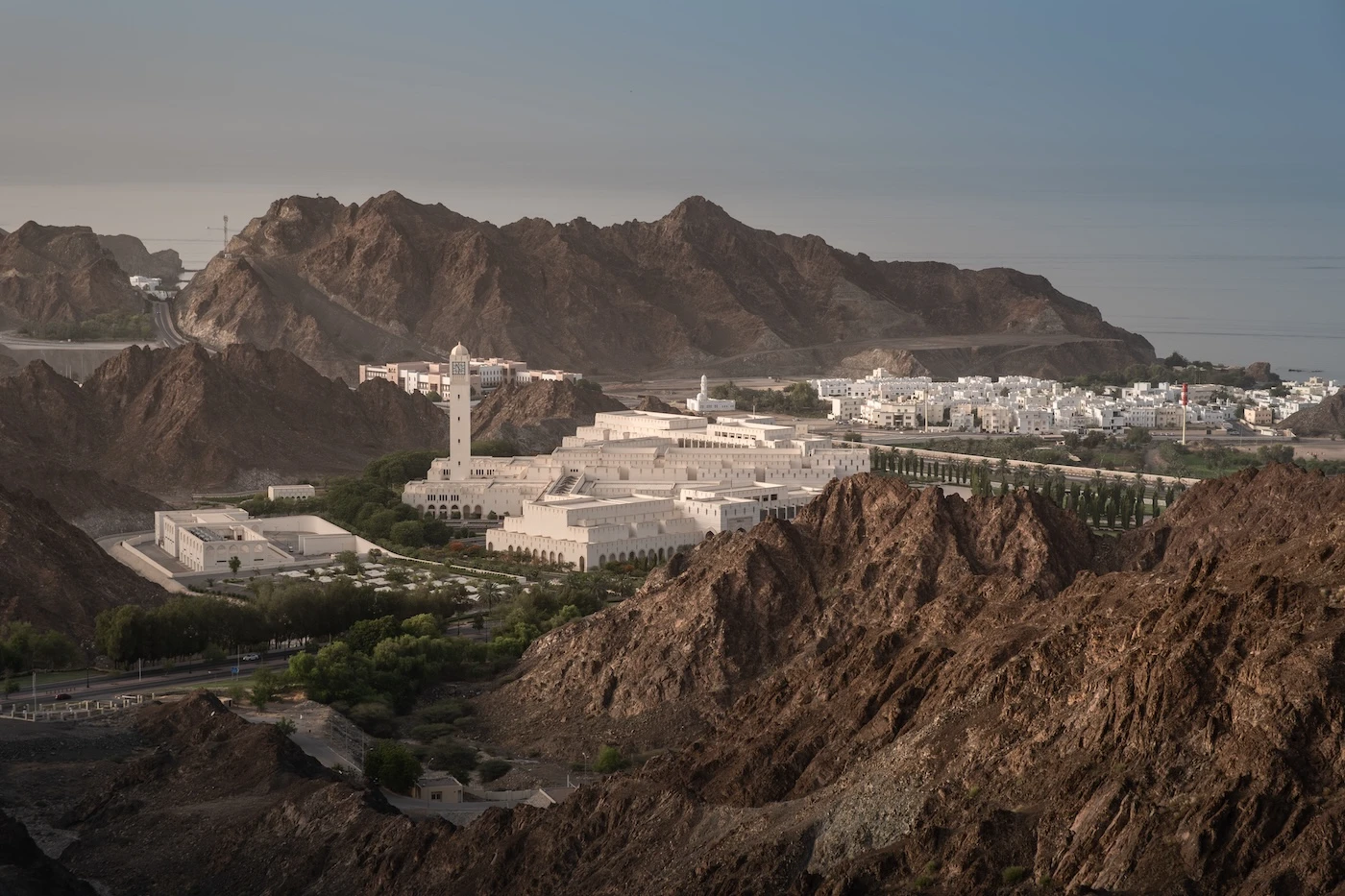 Brilliant white government buildings in Muscat's district of Al Bustan, nestled amongst the rugged mountains.