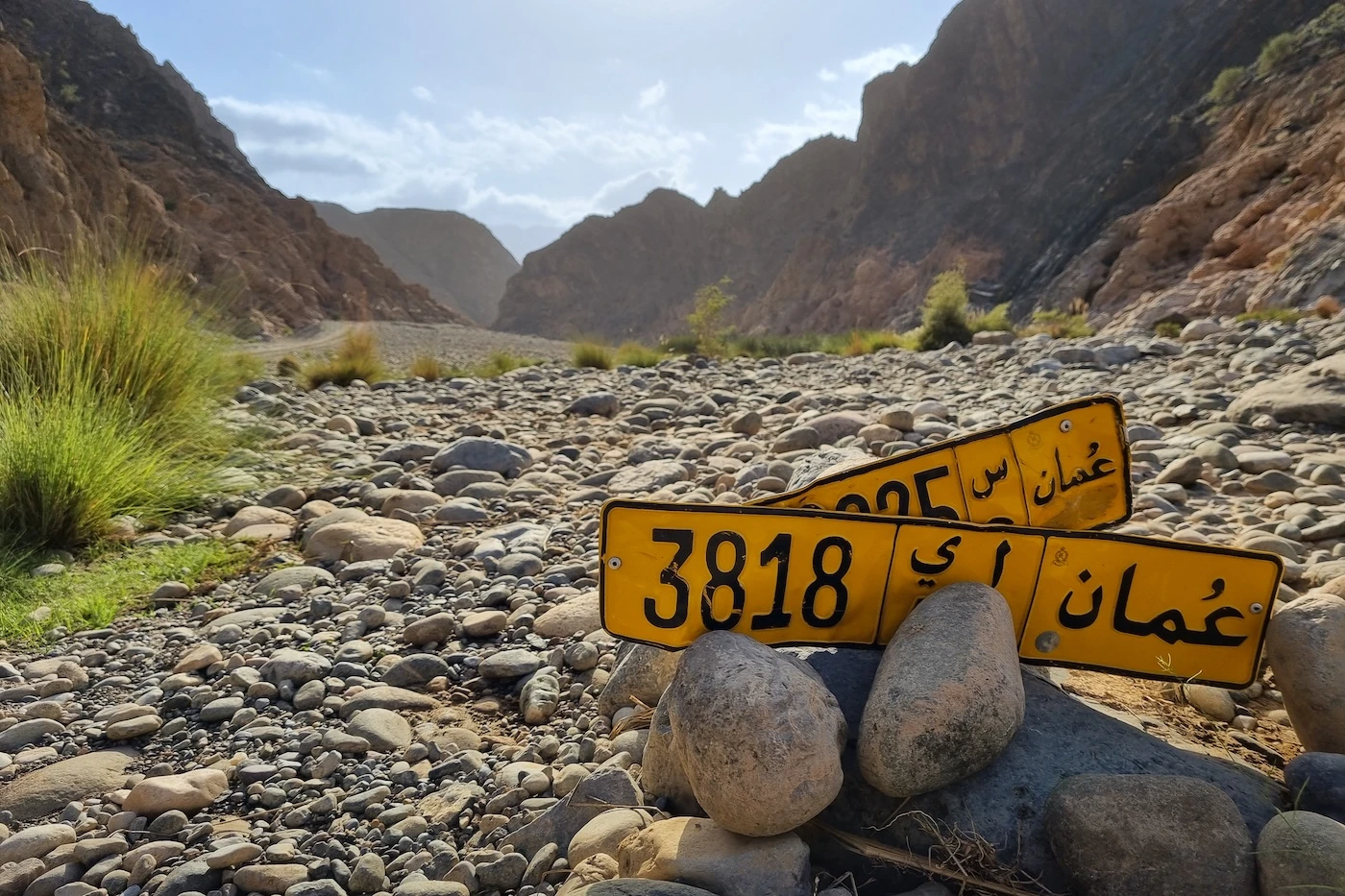 Lost license plates near a rocky river crossing in Oman.