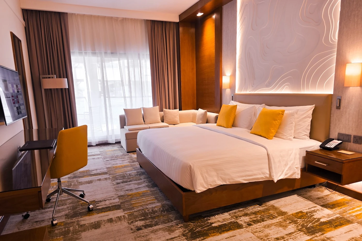 A double bedroom with carpeted floors and modern styling at the Dusit D2 atop Jebel Akhdar.
