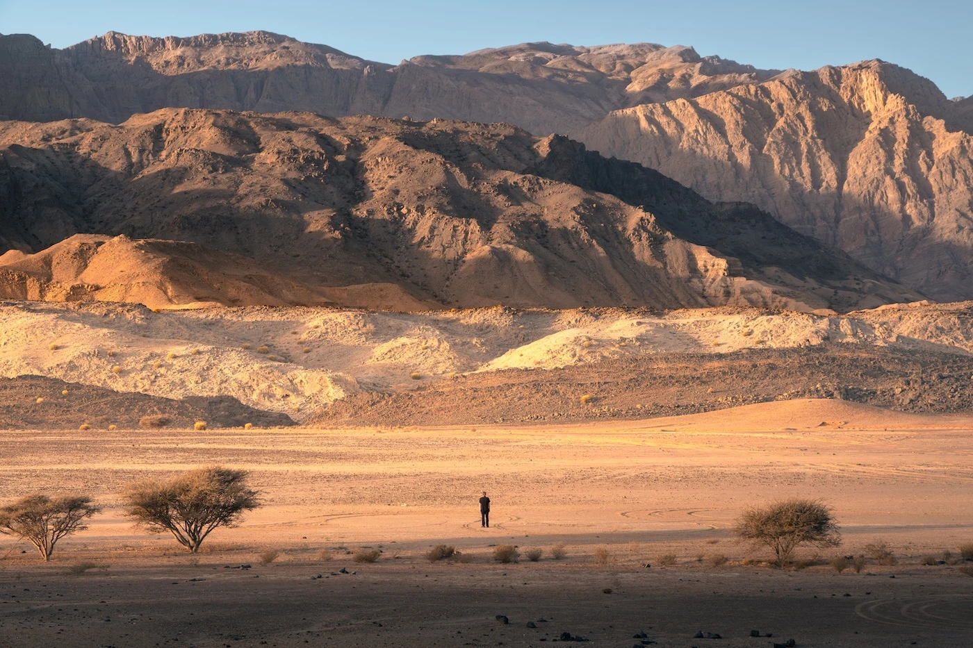 Standing in the savannah-esque plains of the Hajar Mountains at Wadi Dayqah.