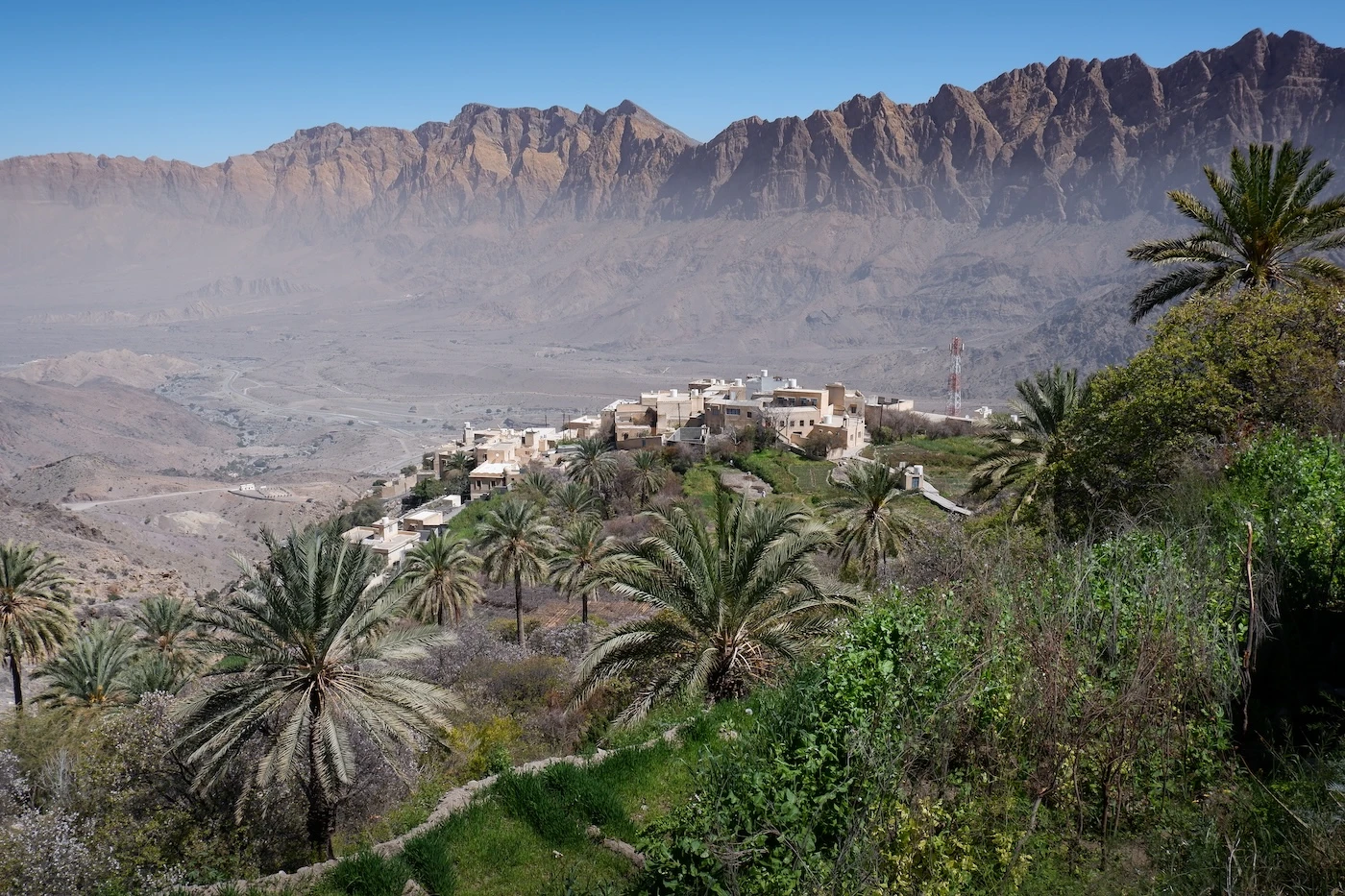 The village of Wakan on a tree-covered cliff-top beside the W25 hiking route in Oman.