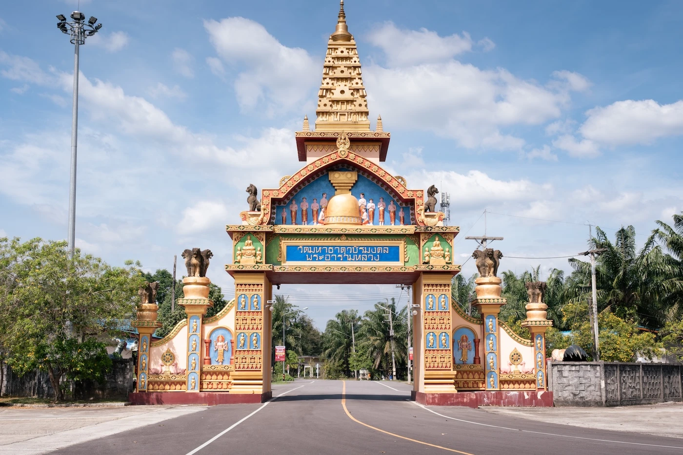 Ornate entrance gate for Wat Bang Thong Temple, featuring a replica gold pagoda tower atop.