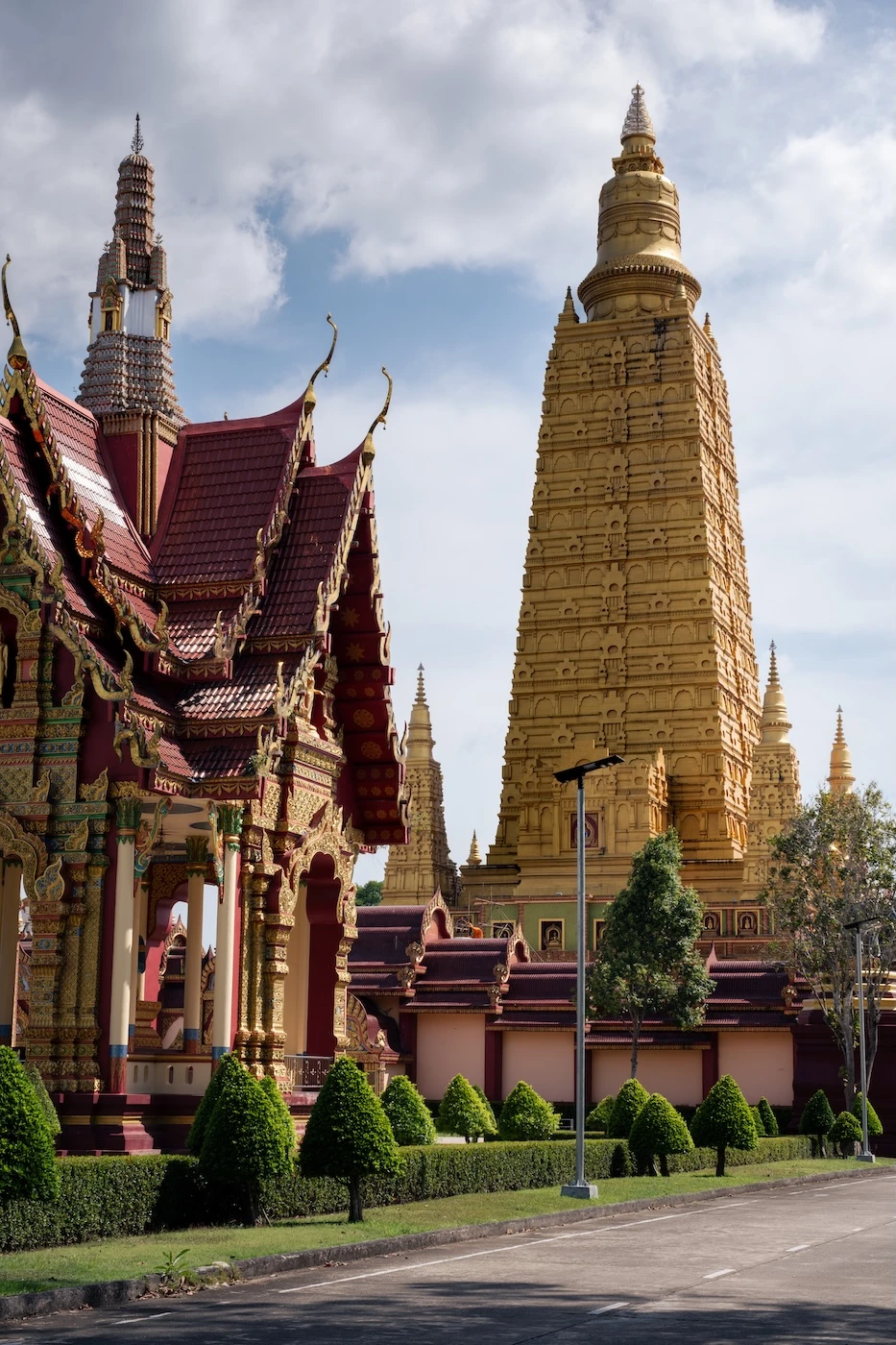 Manicured temple grounds at Wat Bang Thong with the main golden structure towering above in the background.