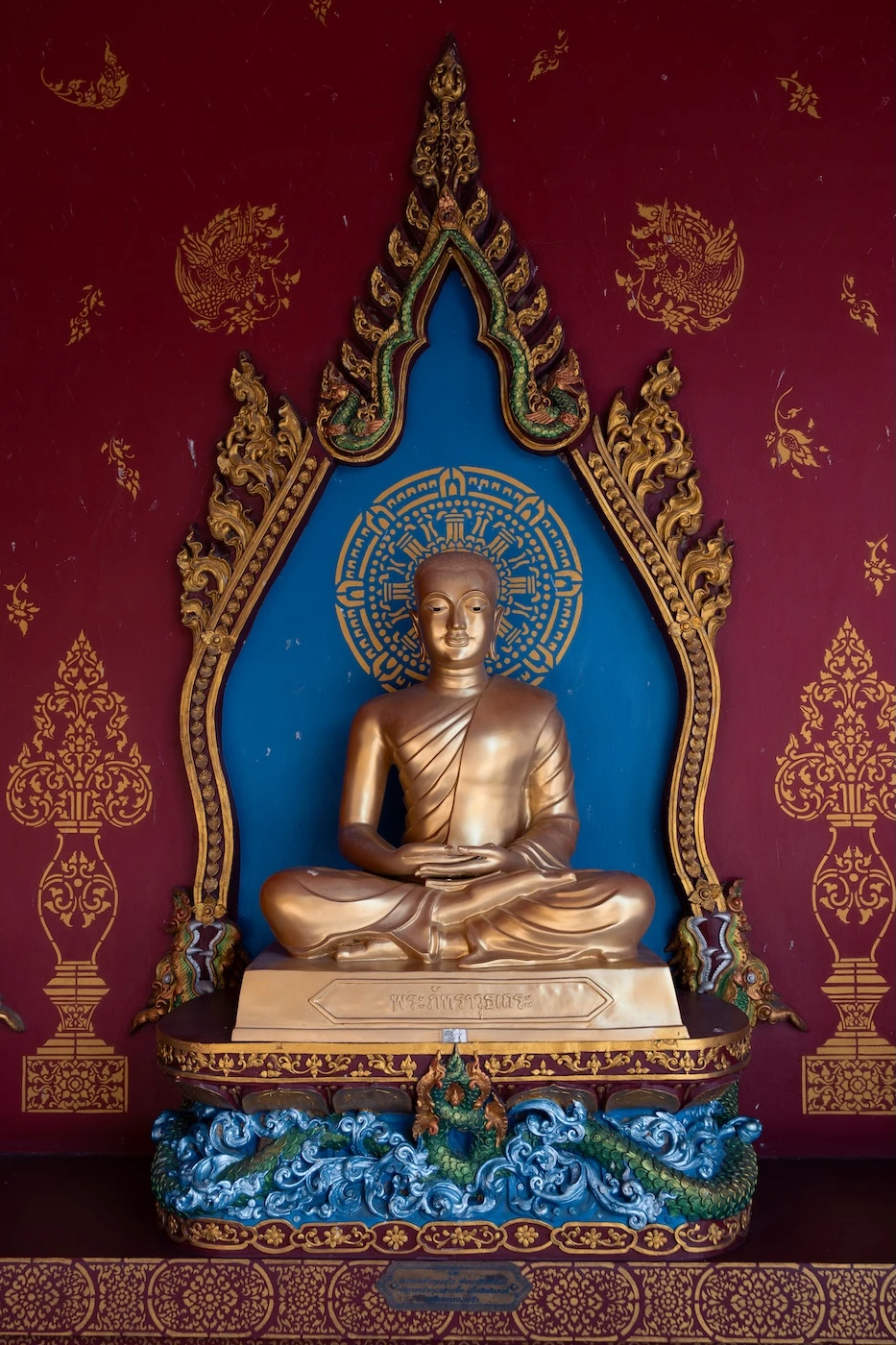 A golden Buddha statue in the seated position inside Wat Bang Thong temple.