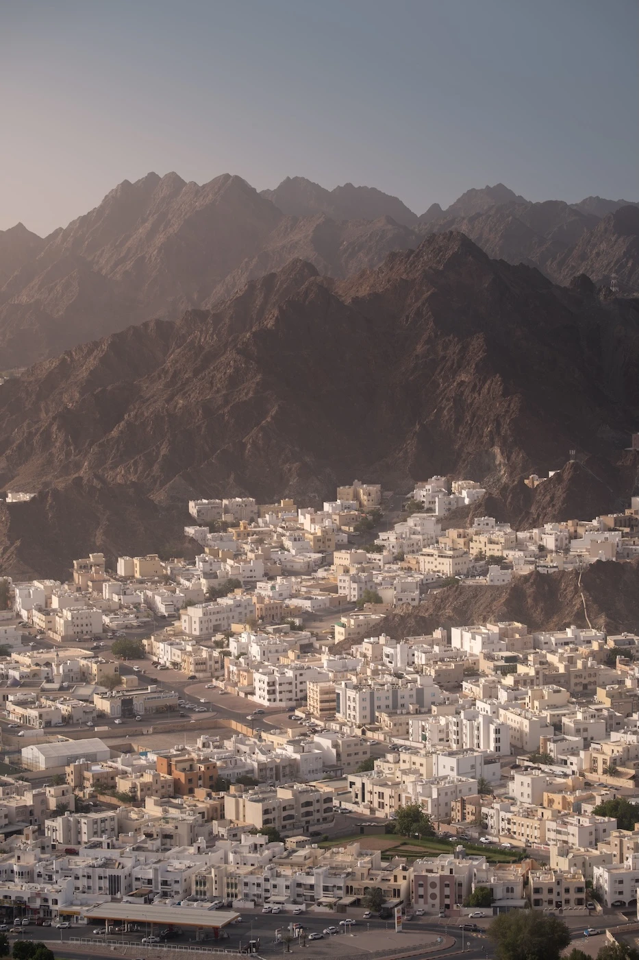 White buildings in Al Wadi Kabir nestled among the rugged mountains around Muscat.